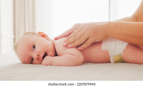 Mother Doing Massage On Her Healthy Infant Baby. Small Caucasian Newborn Laying On His Belly While His Mother Is Performing A Massage For His Small Back And Developing Muscles. 
