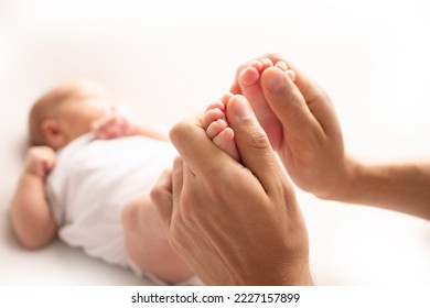 Mother is doing massage on her baby foot. Close up baby feet in mother hands on a white background. Prevention of flat feet, development, muscle tone, dysplasia. Family, love, care, and health concept - Powered by Shutterstock