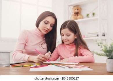 Mother drawing with her daughter. Relationship, motherhood, joint activities and interests, trust, support, caress, maternal warmth, caring, education and early development concept स्टॉक फोटो