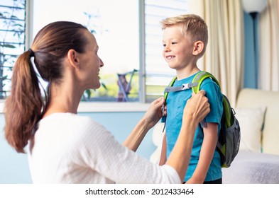 Mother Dressing Up Her Child Getting Ready For First Day Of School. Back To School And Parenting Concept. 