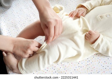 A Mother Dressing Her Little Baby Boy Boy At Home. Childhood Parenthood And Growing Up Family Concept Real People.