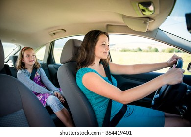 Mother Driving Car And Child Sitting On Back Seat