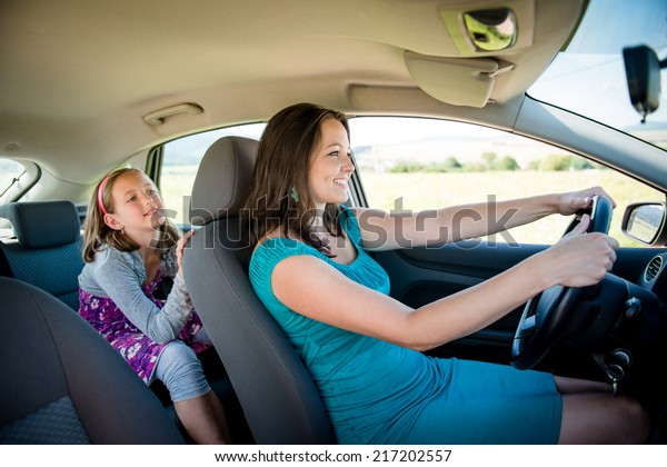Mother driving car and child sitting on back\
seat - no belt,\
dangerous