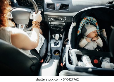 Mother driving car with her baby

