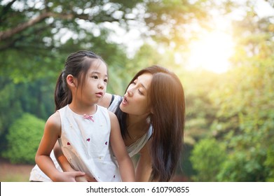 Mother Embracing Daughter In The Park , Asian Family Outdoor Lifestyle, Morning With Sun Flare.