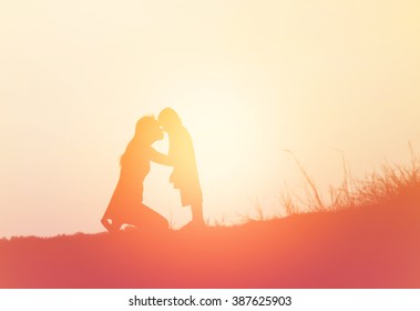 Mother Encouraged Her Son Outdoors At Sunset, Silhouette Concept