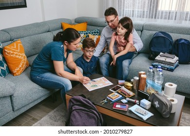 Mother explaining to her family the assembly point map while preparing emergency backpacks