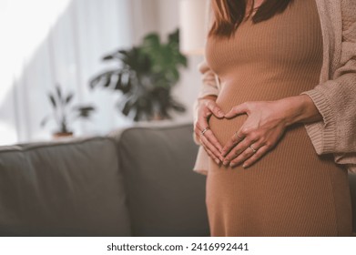 mother, family, maternity, pregnant, woman, pregnancy, baby, motherhood, love, happiness. pregnancy, motherhood, people, close up of happy pregnant woman with big belly near stand sofa and smiling.