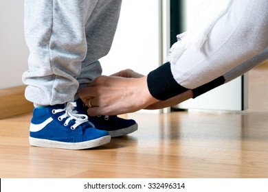 Mother fastens the shoe of his child - Powered by Shutterstock