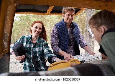 Mother And Father Arrange Things For A Picnic At The Nature. Girl Watches With Interest What Her Parents Doing. Family Weekend Concept