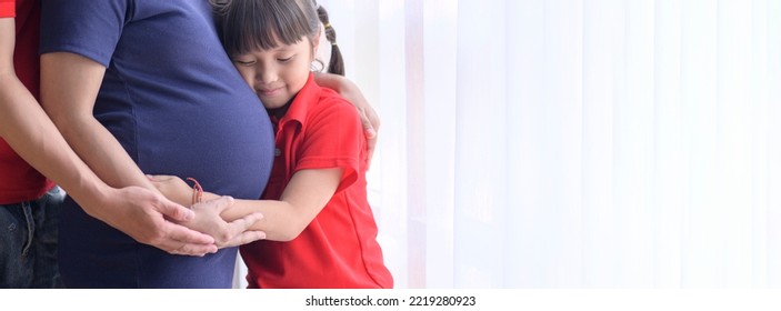 Mother, Father And Baby Daughter Expecting Waiting For A New Family Member,Girl Listening Baby's Heartbeat Hugging Pregnant Mother's Belly.