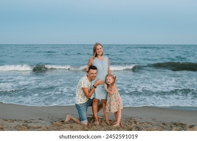 Mother, father and child in love hugging on seashore. Happy family hugs a child barefoot standing on a sand beach. Man hugs pregnant wife. Dad, daughter kisses stomach mom enjoy summer vacation on sea - Powered by Shutterstock