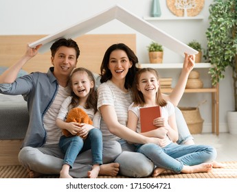 Mother, father and children girls in the room with a symbol of roof. Concept of housing for young family.      