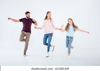 Mother, Father And Daughter Dancing Together In Studio  Isolated On White