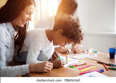 Mother And Father Drawing Together With Their Child