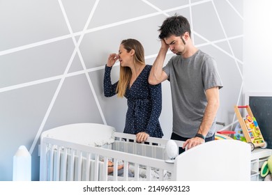 Mother And Father In Front Of Their Son's Crib Horrified By The Bad Smell