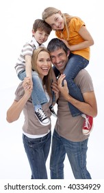 Mother And Father Giving Children Piggy Back Ride Against White Background