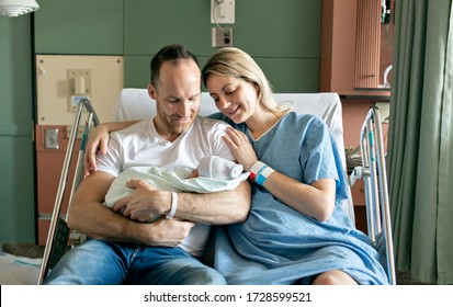 A Mother and father with her newborn baby at the hospital a day after a natural birth labor - Powered by Shutterstock