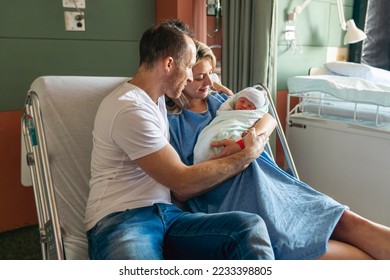 A Mother and father with her newborn baby at the hospital a day after a natural birth labor - Powered by Shutterstock