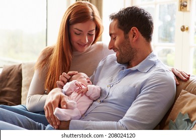 Mother And Father At Home With Newborn Baby