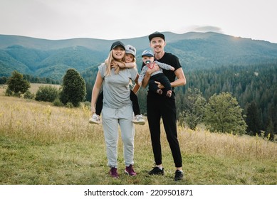 Mother, father hug childs in autumn. Family with kids hiking on grass on top of a mountains. Tourists enjoy valley view sunset. Mom, dad, son, and daughter. Holiday trip concept. World Tourism Day. - Powered by Shutterstock