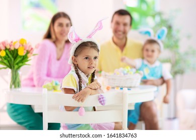 Mother, Father And Kids Color Easter Eggs. Mom, Dad, Little Girl And Boy With Bunny Ears Dying And Painting For Easter Egg Hunt. Family And Child Celebration. Home Decoration For Spring Holiday.