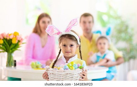 Mother, Father And Kids Color Easter Eggs. Mom, Dad, Little Girl And Boy With Bunny Ears Dying And Painting For Easter Egg Hunt. Family And Child Celebration. Home Decoration For Spring Holiday.