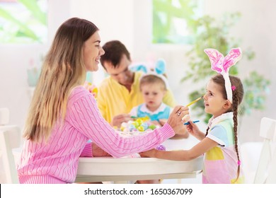 Mother, Father And Kids Color Easter Eggs. Mom, Dad, Little Girl And Boy With Bunny Ears Dying And Painting For Easter Egg Hunt. Family And Child Celebration. Home Decoration For Spring Holiday.