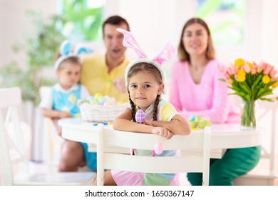 Mother, Father And Kids Color Easter Eggs. Mom, Dad, Little Girl And Boy With Bunny Ears Dying And Painting For Easter Egg Hunt. Family And Child Celebration. Home Decoration For Spring Holiday.