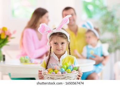 Mother, Father And Kids Color Easter Eggs. Mom, Dad, Little Girl And Boy With Bunny Ears Dying And Painting For Easter Egg Hunt. Family And Child Celebration. Home Decoration For Spring Holiday.