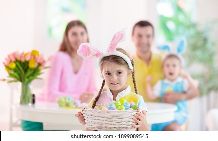 Mother, Father And Kids Color Easter Eggs. Mom, Dad, Little Girl And Boy With Bunny Ears Dying And Painting For Easter Egg Hunt. Family And Child Celebration. Home Decoration For Spring Holiday.