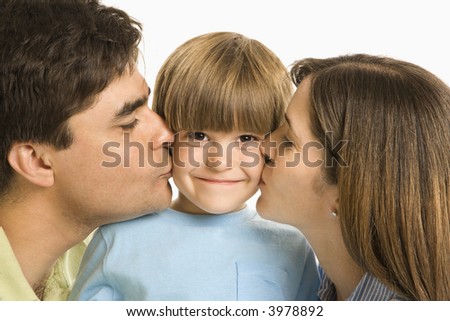 Mother and father kissing son on opposite cheeks.