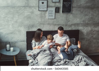 Mother, father and two sons  on the bed. Christmas. - Shutterstock ID 560443585