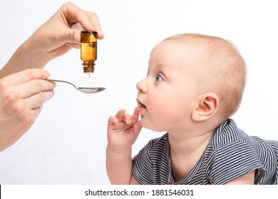 Mutter, die einen Säugling mit Vitamin- oder Flüssigmedizin mit Löffel ernährt