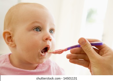 Mother Feeding Baby Food To Baby