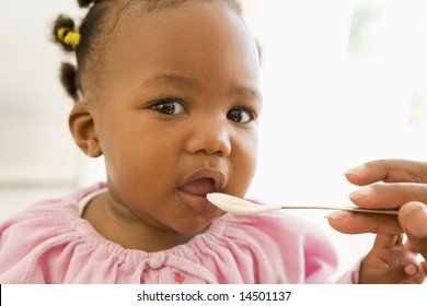 Mother Feeding Baby Food To Baby