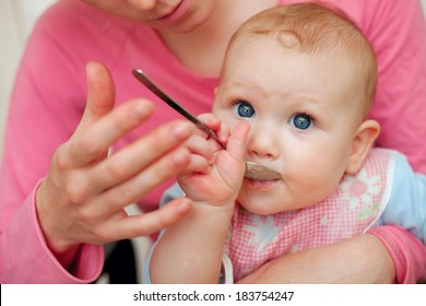 Mother Feeding Baby Food To Baby