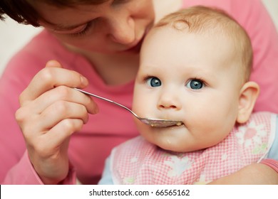 Mother Feeding Baby Food To Baby