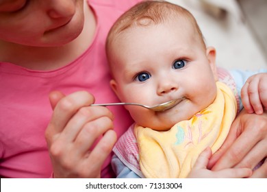 Mother Feeding Baby Food To Baby