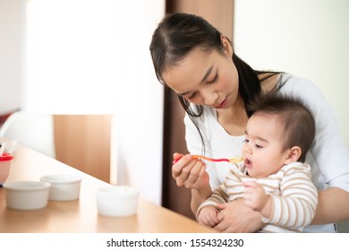 Mother Feeding Baby Food To Her Baby