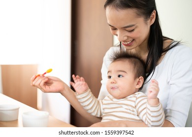 Mother Feeding Baby Food To Her Baby
