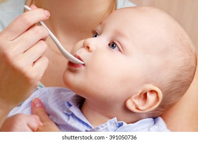 Mother Feeding Baby Baby Food With A Spoon