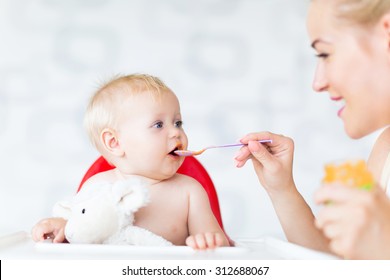 Mother Feeding Baby With Spoon