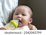 Mother is feeding milk to Asian baby, Asian baby drinks milk