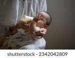 Mother is feeding milk to Asian baby, Asian baby drinks milk
