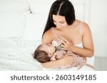 a mother feeds a baby from a bottle, a mother holds a newborn baby in her arms and feeds milk from a bottle.