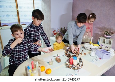 Mother with four kids makes a wreath for Christmas Eve and crafting decorating. New Year celebration. - Shutterstock ID 2140745197