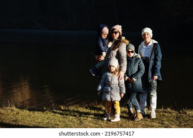 Mother With Four Kids In Pound At Early Spring Park.