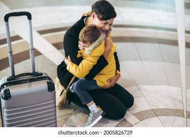 Mother getting emotional with her child at airport. Mother and son meeting at airport. - Powered by Shutterstock