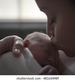 Mother Gives Newborn Baby A Kiss In Hospital Delivery Room